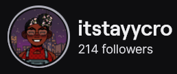 ItsTayyCro's Twitch logo and follower count (214). Logo is a cartoon style picture of a smiling black woman wearing a head wrap and red and green jumper dress. Image links to ItsTayyCro's Twitch page.