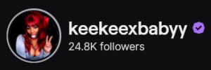 KeeKeeXBabyy's Twitch logo and follower count (24.8k). Logo is a picture of a black woman with ruby red hair, making a peace sign finger pose, and sticking her tongue out.
Image links to KeeKeeXBabyy's Twitch page.
