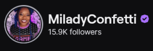 MiladyConfetti's Twitch logo and follower count (15.9k). Logo is a picture of a smiling black woman with dark blue braids and a black t-shirt that says "Game over." Image links to MiladyConfetti's Twitch page.
