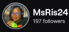 MsRis24's Twitch logo and follower count (197). Logo is a picture of a smiling black woman with black/blue headphones and holding a neon green game pad/controller. Image links to MsRis24's Twitch page.