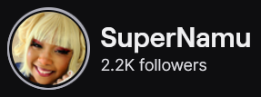 SuperNamu's Twitch logo and follower count (2.2k). Logo is a picture of a smiling black woman with yellow blonde hair and straight bangs. She's cosplaying Himiko Toga from My Hero Academia. Image links to SuperNamu's Twitch page.
